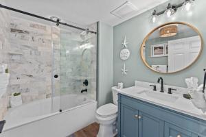 a bathroom with a tub and a sink and a mirror at Sunrise Surprise 9th floor 2BR 2 BA King Suite Beach shuttle, heated pool! in Destin +44 photos