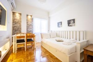 a small bedroom with a bed and a desk at Acropolis Delux 1st FLR Aprt up 4 guests by LODGESPOT in Athens