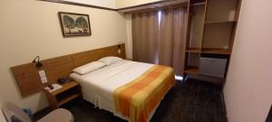 a hotel room with a bed and a chair at Hotel Pousada São Francisco in Olinda