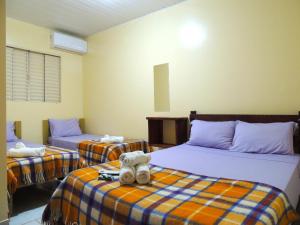 a room with two beds with a teddy bear on them at Pousada Santa Rita in Abadiânia