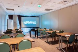 a classroom with tables and chairs and a projection screen at Grand Hôtel De La Seine in Rouen
