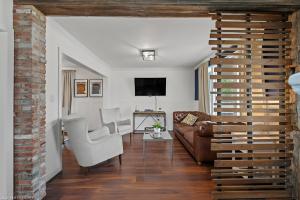 a living room with a couch and a tv at 4 Bedroom Luxury House, Free Parking, Next to LRT, Kitchener Downtown, near Chicopee Ski Club in Kitchener