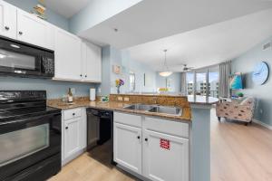 una cocina con fregadero y estufa horno superior en Stunning Resort 11th Fl Pool & Gulf View King Suite Across From Beach, en Destin