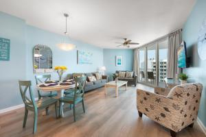 Una sala de estar con una mesa y sillas y un sofá. en Stunning Resort 11th Fl Pool & Gulf View King Suite Across From Beach, en Destin