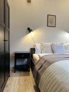 a bedroom with a bed and a table with a lamp at APARTAMENTY LAVENDERIA z widokiem na Górę Parkową, blisko centrum in Kudowa-Zdrój