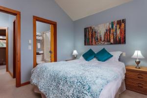 Un dormitorio con una cama grande con paredes azules. en BigWhite Ski In-Out Chalet w Priv HotTub & Garage, en Big White 8 fotos más