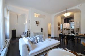 ein Wohnzimmer mit einem weißen Sofa und einem Esszimmer in der Unterkunft Cocoma-Design-Apartment Deluxe - very central in München
