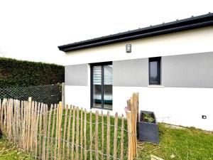 a white house with a fence in front of it at Maison à 100m de la mer in Hermanville-sur-Mer