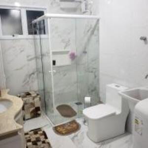 Un baño blanco con ducha y WC. en Casa de 2 Plantas, en São Gabriel