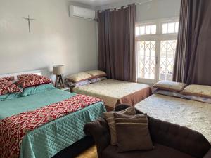 Un dormitorio con dos camas y una ventana. en Casa de 2 Plantas, en São Gabriel