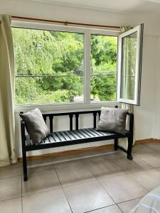 a bench sitting in front of a large window at Departamento céntrico 1 in El Bolsón