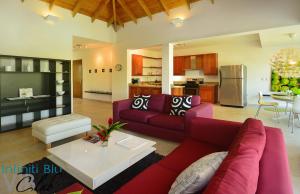a living room with a red couch and a table at Infiniti Blu Luxury Ocean Front Condos in Sosúa