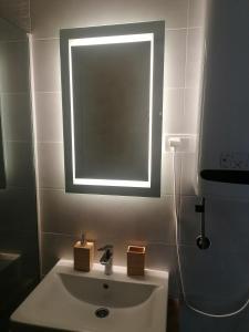 a bathroom sink with a window and a mirror at DivčiNova apartman Gnezdo in Divčibare