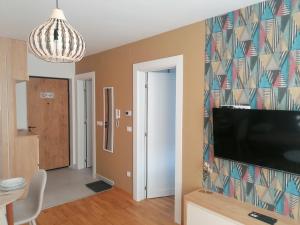 a living room with a flat screen tv on a wall at DivčiNova apartman Gnezdo in Divčibare