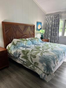 a bedroom with a bed with a bedspread with palm trees at Great Cistern Beach Village in Marsh Harbour