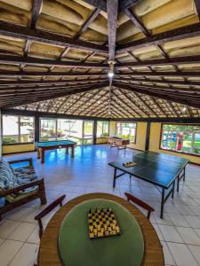 a large room with a ping pong table and chess at Pousada Pontal da Praia in São Pedro da Aldeia