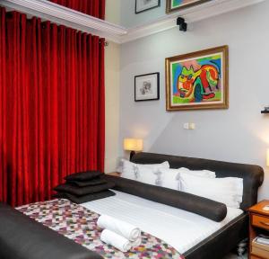 Un dormitorio con una cama con una cortina roja. en Grand Casamora Hotel, en East Legon