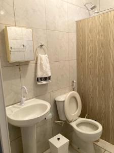 a small bathroom with a toilet and a sink at Pousada Santa Rita in Abadiânia