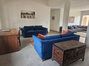 a living room with blue couches and a table at premium farmhouse with pool Rabat in Rabat +85 photos