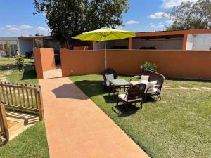 a patio with a table and chairs and an umbrella at premium farmhouse with pool Rabat in Rabat