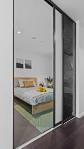 una camera da letto con un letto e una grande finestra di vetro di The Downtown Nest a Melbourne Altre 15 foto