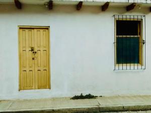 ein weißes Gebäude mit gelber Tür und Fenster in der Unterkunft Casa Copal in San Cristóbal de las Casas