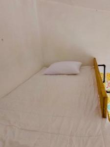 ein weißes Bett mit Kissen in einem Zimmer in der Unterkunft Casa Copal in San Cristóbal de las Casas