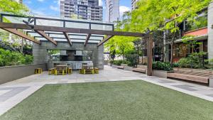 un patio esterno con tavoli, sedie e alberi di The Downtown Nest a Melbourne