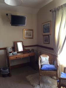 um quarto com uma secretária, um espelho e uma cadeira em The Bull Inn West Tanfield em Ripon