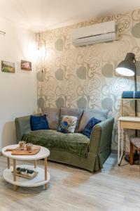 a living room with a green couch and a table at La p'tite Auxerroise, mini-maison avec jardin ! in Auxerre