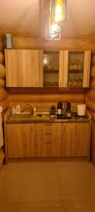 Una cocina con gabinetes de madera y un fregadero. en Cabana Deluț, en Borşa