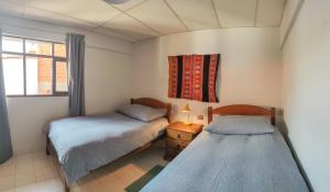 a bedroom with two beds and a window at Hostal Margaritas - Torotoro in Torotoro