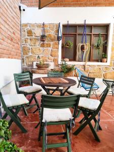 a patio with chairs and tables and a stone wall at Hostal Margaritas - Torotoro in Torotoro +55 photos