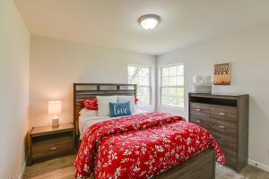 a bedroom with a bed with a red comforter and a window at Chic Columbia Home Less Than 2 Mi to Historic Square! in Columbia