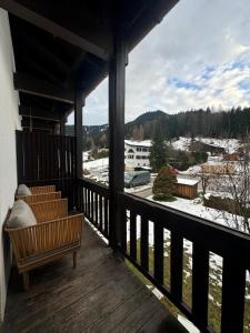 a porch with a bench and a view of a town at Modernes Serviced Apartment - FeWo Morgenglanz in Berchtesgaden
