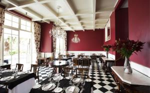 un restaurante con paredes rojas, mesas y sillas en Hotel Isla Seca, en Zapallar