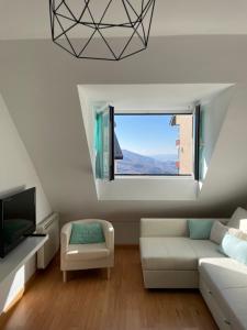ein Wohnzimmer mit einer weißen Couch und einem Fenster in der Unterkunft HOUSE TUVESA PREMIUM 1 DORMITORIO WIFI GRATiS in Sierra Nevada