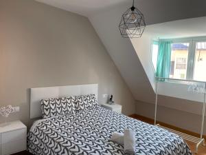 Schlafzimmer mit einem schwarzen und weißen Bett und einem Fenster in der Unterkunft HOUSE TUVESA PREMIUM 1 DORMITORIO WIFI GRATiS in Sierra Nevada