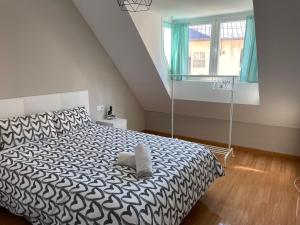 Schlafzimmer mit einem schwarzen und weißen Bett und einem Fenster in der Unterkunft HOUSE TUVESA PREMIUM 1 DORMITORIO WIFI GRATiS in Sierra Nevada