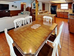 a dining room and kitchen with a wooden table and chairs at The Hidden Porpoise in Port Aransas