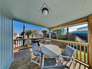 a table and chairs on a deck with a view of the beach at The Hidden Porpoise in Port Aransas