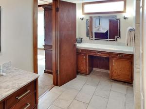 a kitchen with wooden cabinets and a sink and a mirror at The Hidden Porpoise in Port Aransas