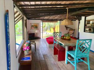 a living room with a table and blue chairs at FARE TEHAKI - Island spirit in Moorea