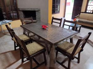 Casa amplia barrio privado Miramar في ميرامار: طاولة غرفة الطعام مع الكراسي وطاولة مع دمية الدب على أعلى