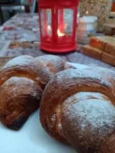 three loaves of bread on a table with a red candle at Il Sentiero beb in Verona +53 photos