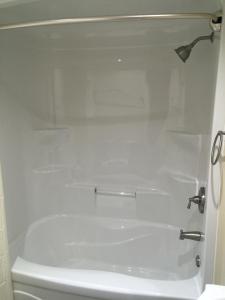 une salle de bain avec une baignoire blanche et des toilettes dans l'établissement Victoria Harbour Cottages, à Victoria Harbour