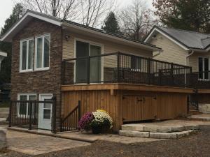 une maison avec une grande terrasse au-dessus dans l'établissement Victoria Harbour Cottages, à Victoria Harbour