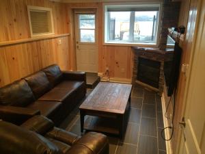 - un salon avec un canapé en cuir et une table basse dans l'établissement Victoria Harbour Cottages, à Victoria Harbour