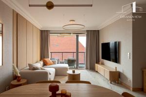 a living room with a couch and a tv at Penthouse Brabank Japandi Luxury Sauna, Fitness & Parking by Grandview in Gdańsk