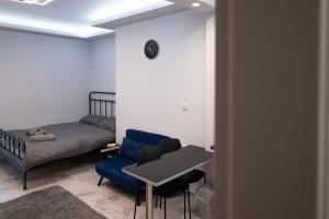 a living room with a bed and a blue couch at Elario studio in Larisa